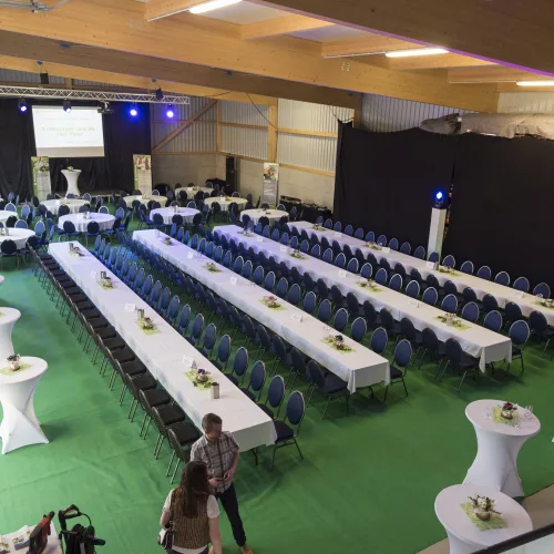 Hier wurde eine neue Halle eröffnet. Zu diesem Anlass wurden eckige Tische und blaue gepolstere elegante Sesseln gemietet um gleich in der Halle die Firmenfeier zu veranstalten