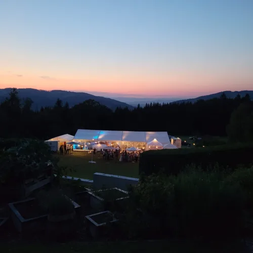 Hochzeit im Zelt - Zelt von außen in der Dämmerung - Beleuchtung des Zeltes sieht man gut.